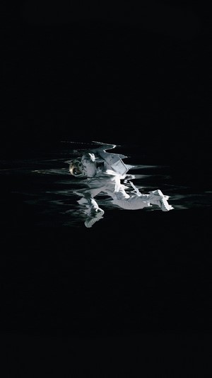 Astronaut floating in dark water