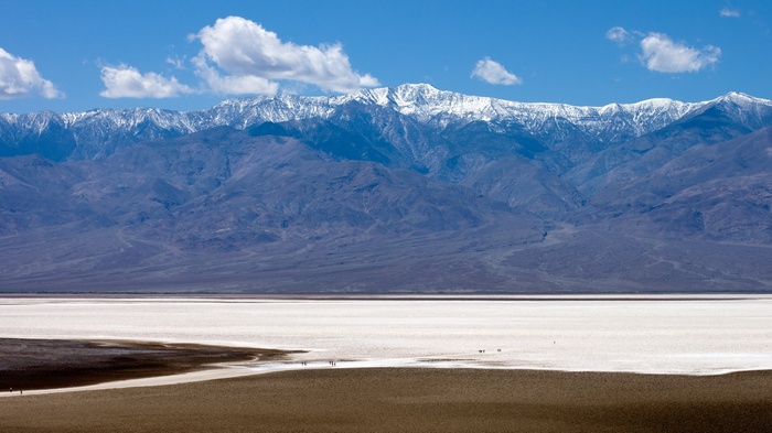 Snow-capped mountains over a salt flat