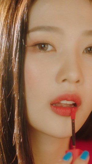 Joy from Red Velvet applying lipstick