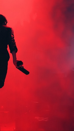 Person holding a microphone in red smoke