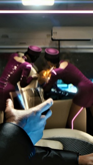 Two women in purple uniforms fighting in a vehicle