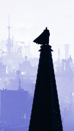Batman standing on a spire overlooking Gotham City