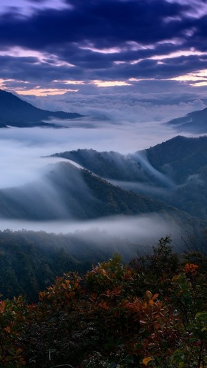 Misty mountains at sunrise with purple clouds