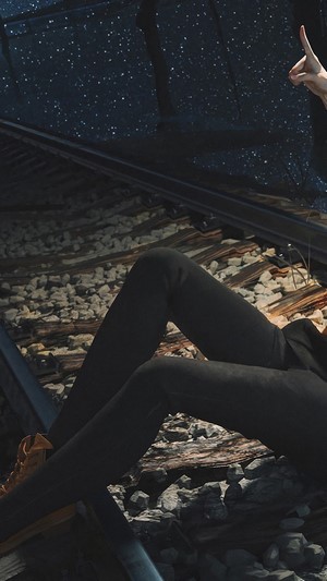 Girl on train tracks at night