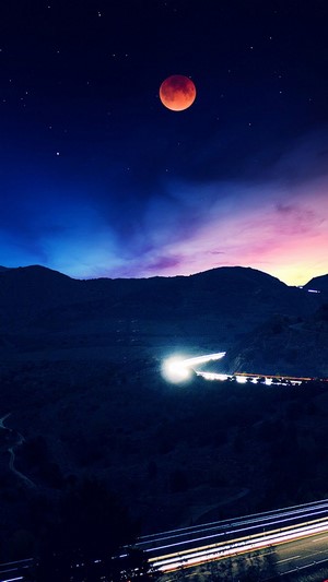 Blood Moon over a Mountain Road at Night