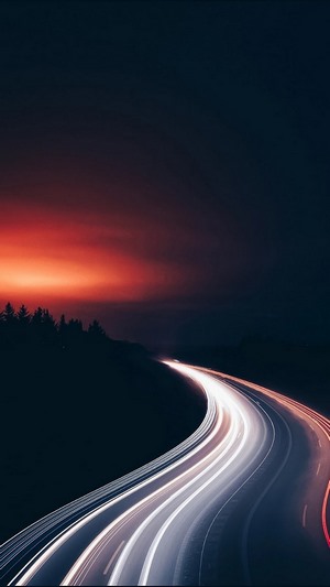 Highway at night with light trails during sunset