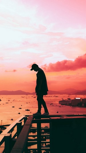 Silhouette of a person on a rooftop at sunset