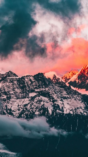 Snow-capped mountains under a colorful sunset sky