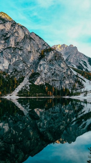 Mountain lake reflection with rocky peaks and blue sky