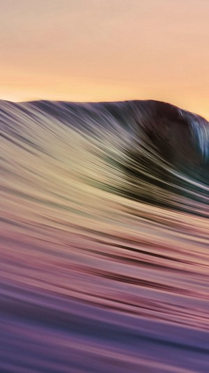 Ocean wave with colorful reflections at sunset