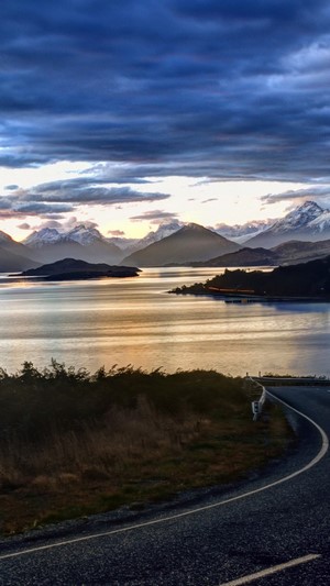 Mountain landscape with lake and road at sunset