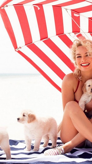 Margot Robbie with puppies on the beach