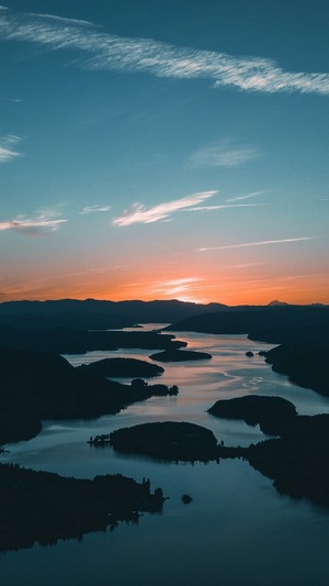 Sunrise over a lake with islands and mountains