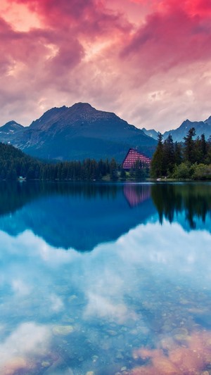 Lake and mountains with a building and forest