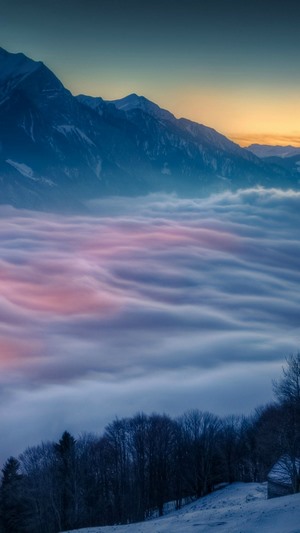 Mountains above clouds at sunset