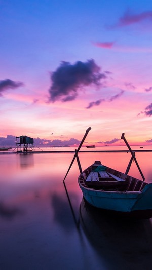 Boat and stilt house at sunset