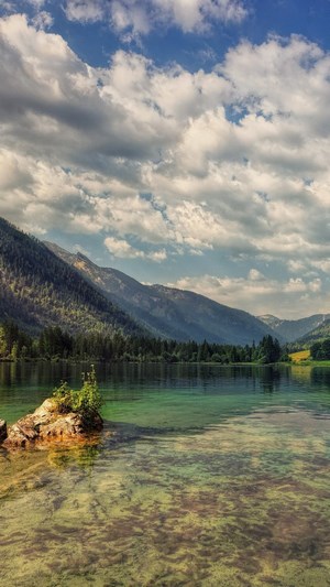 Mountains and a clear lake with clouds in the sky