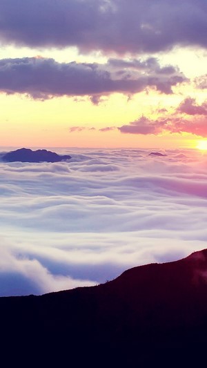 Sunrise over clouds with mountains