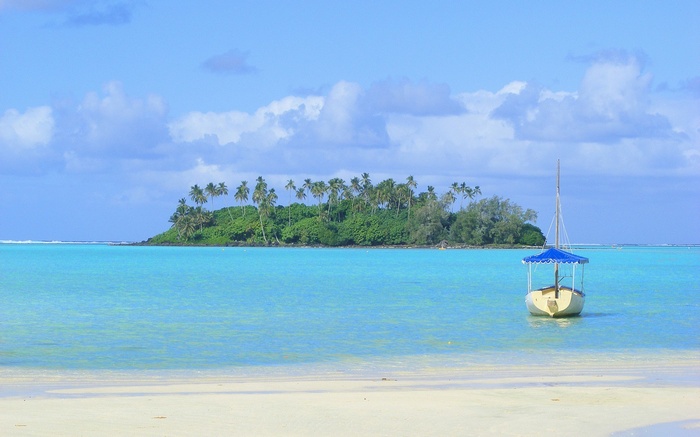 Tropical island with palm trees and a sailboat