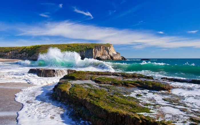 Waves crashing on a rocky shore with a cliff