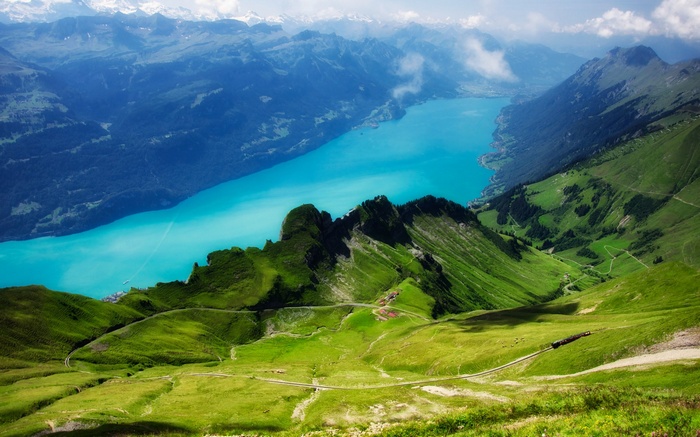 Turquoise lake surrounded by mountains and green hills