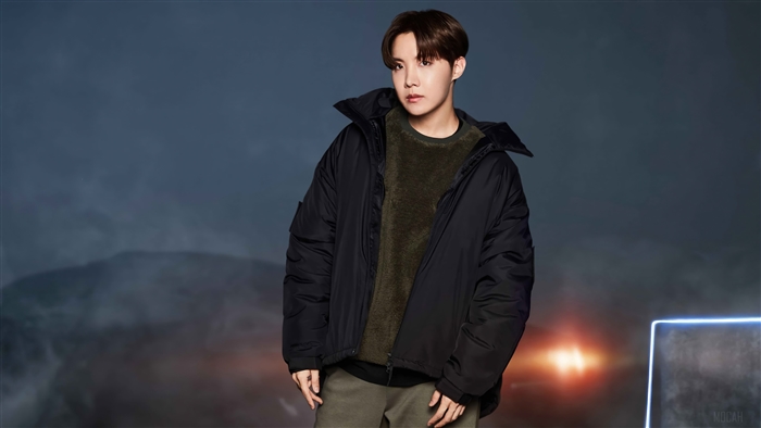 J-Hope from BTS wearing a black puffer jacket and green sweater