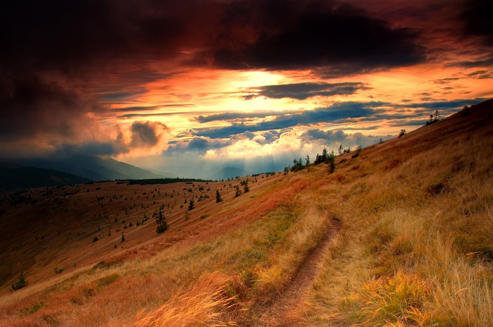 Mountain trail at sunset with dramatic clouds