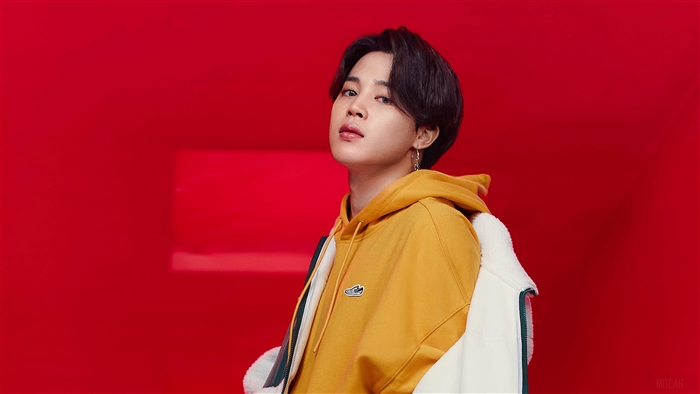 Jimin from BTS wearing a yellow hoodie