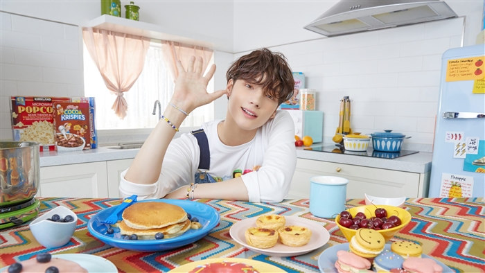 Huening Kai from TXT in a kitchen with breakfast foods