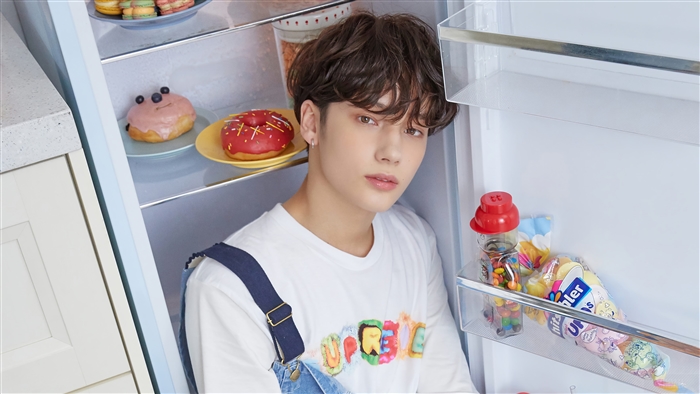 Huening Kai from TXT in a refrigerator with snacks