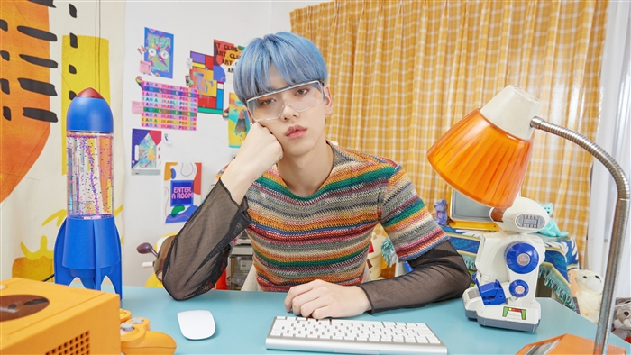 Soobin from TXT wearing glasses and a colorful shirt
