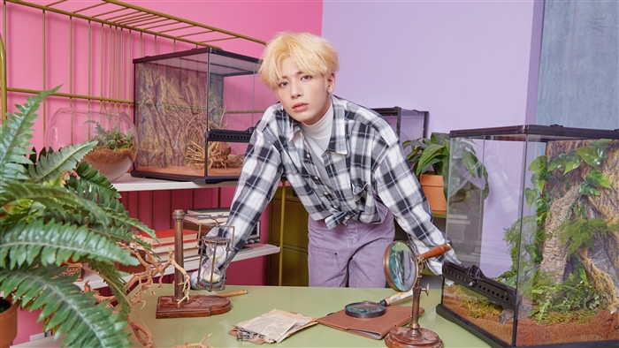 Taehyun from TXT in a study with terrariums