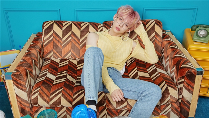 Yeonjun from TXT on a patterned couch