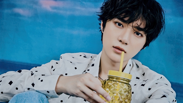 Beomgyu from TXT holding a yellow cup