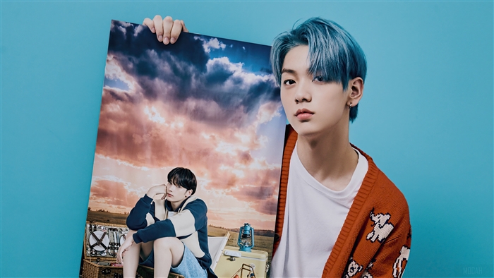 Soobin from TXT holding a photoshoot poster