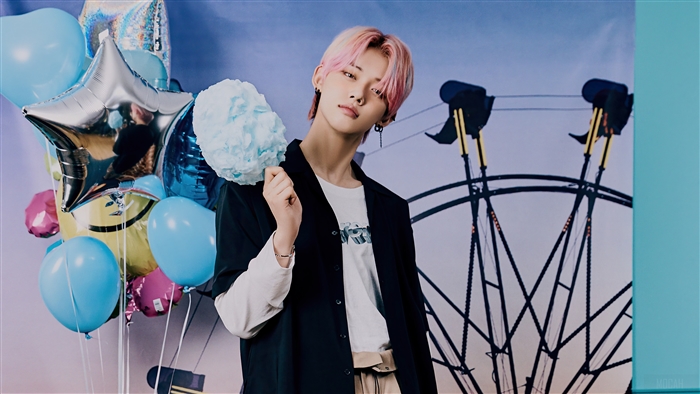 Yeonjun from TXT holding cotton candy with balloons and Ferris wheel