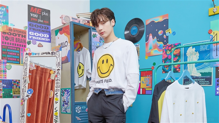 Huening Kai from TXT in a room with posters