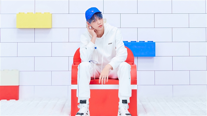 Soobin from TXT wearing a white hoodie and blue cap
