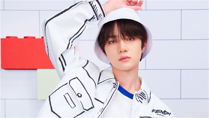 Beomgyu from TXT wearing a bucket hat and jacket