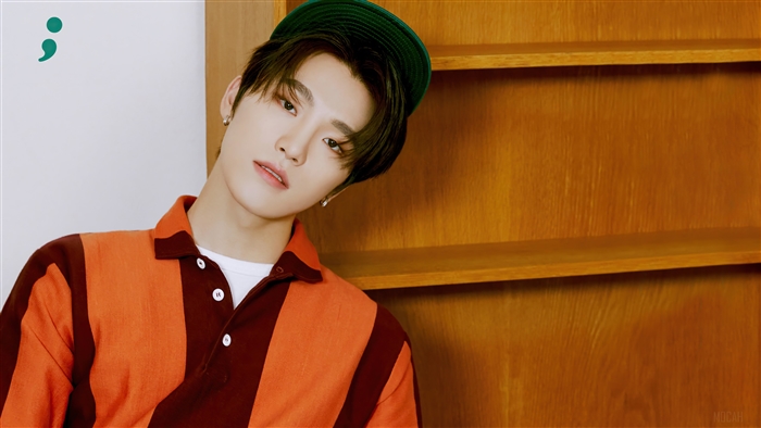 Dino from Seventeen wearing a green cap and striped shirt
