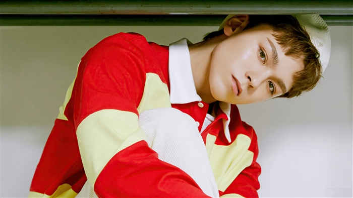 Vernon from Seventeen wearing a red and yellow shirt