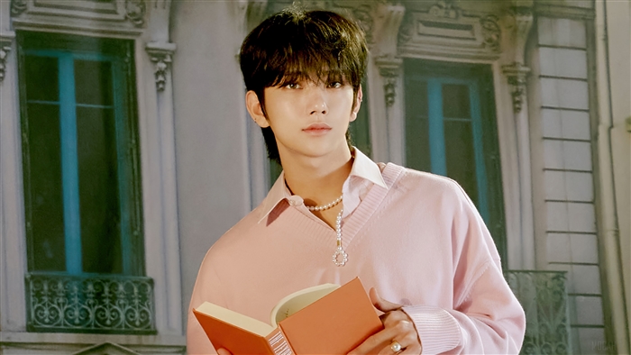 Joshua from Seventeen holding a book