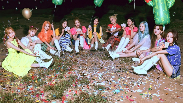 LOONA members sitting on the ground with balloons and confetti