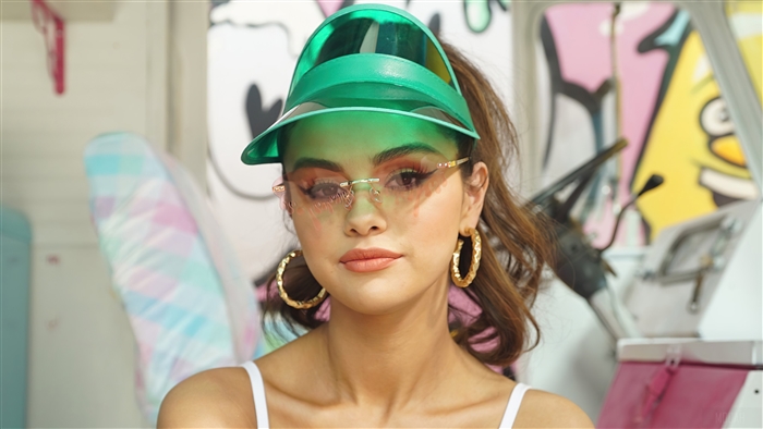 Selena Gomez wearing sunglasses and a visor