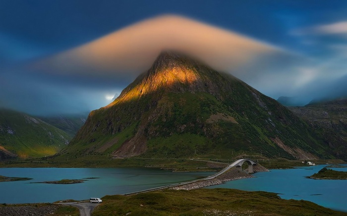 Mountain with lenticular cloud over a bridge and lake