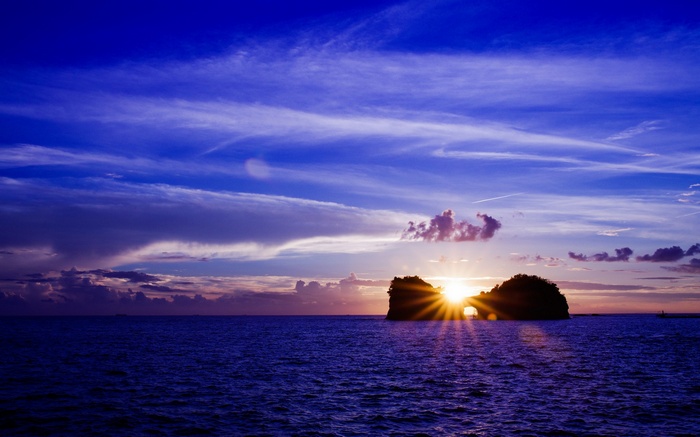 Sunset over the ocean with a rock formation