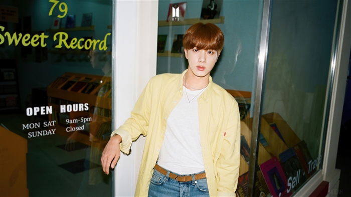 Jin from BTS in front of a record store