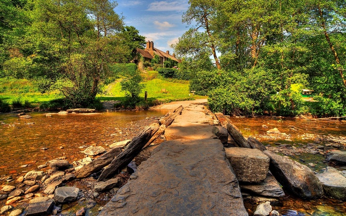 Stone bridge over a stream leading to a house