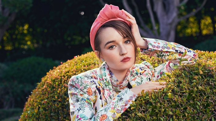 Kaitlyn Dever in a floral jacket and pink headband