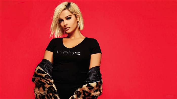 Bebe Rexha wearing a black Bebe t-shirt and leopard print jacket